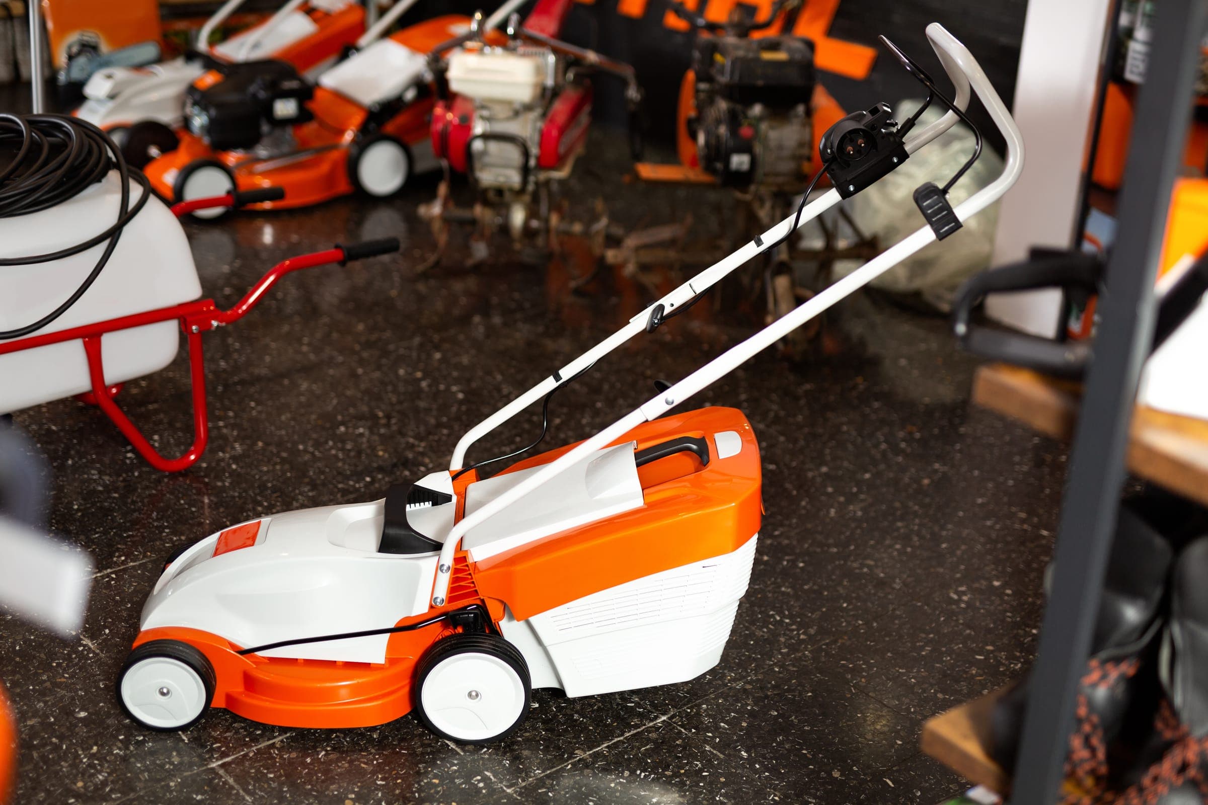 White and orange lawn mower in a garden shop
