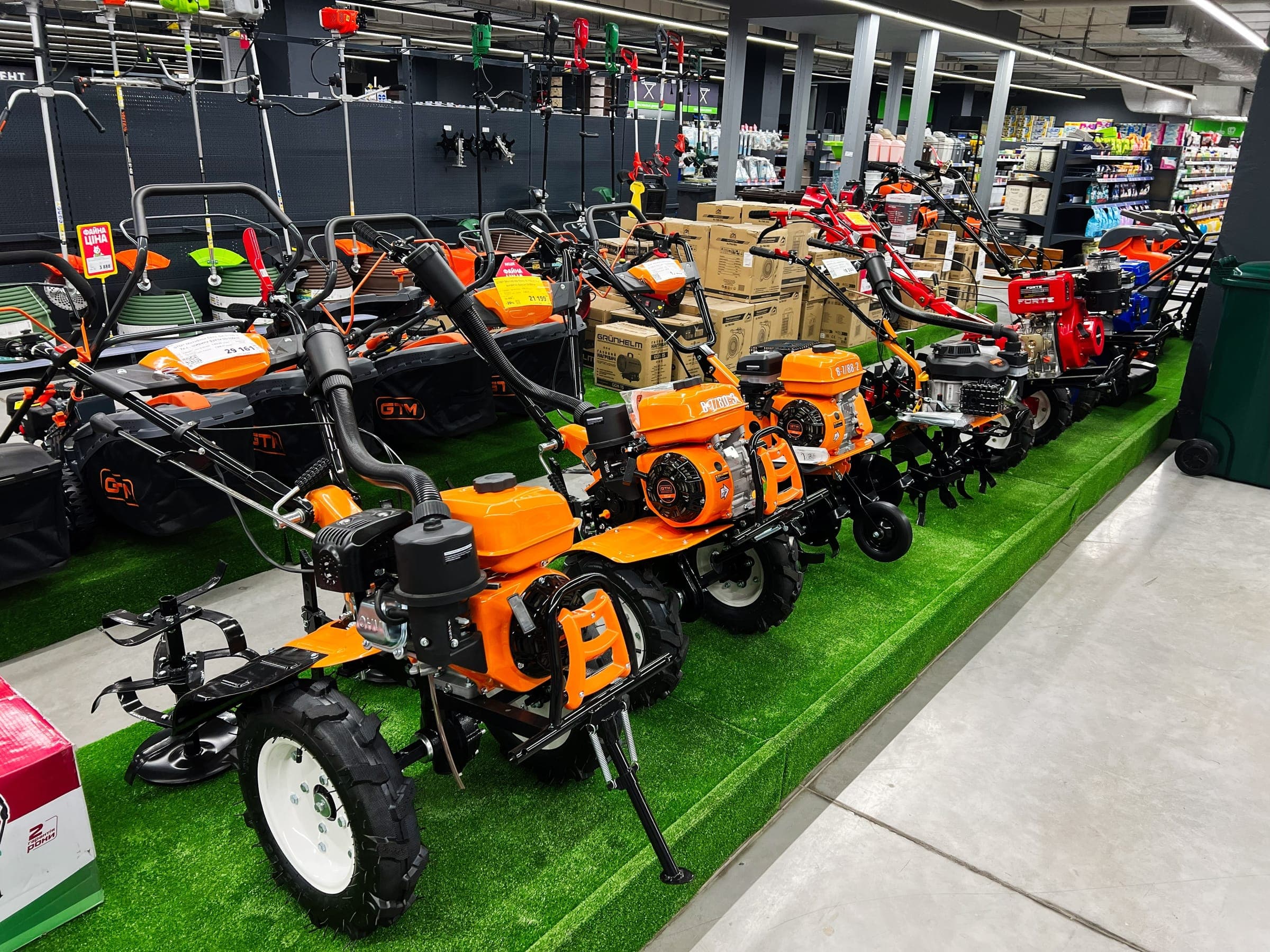 Orange power tillers on a grass display